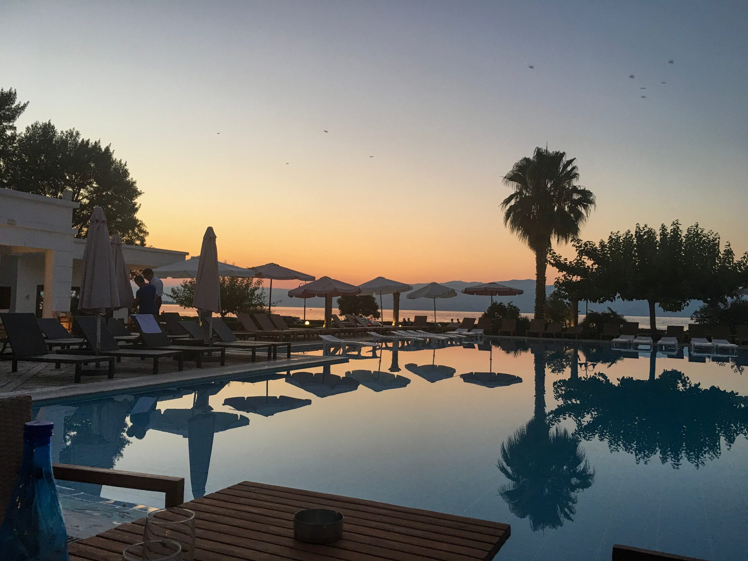 basen z leżakami w Grecji o zachodzie słońca. Ceny leżaków i jedzenia w Grecji.